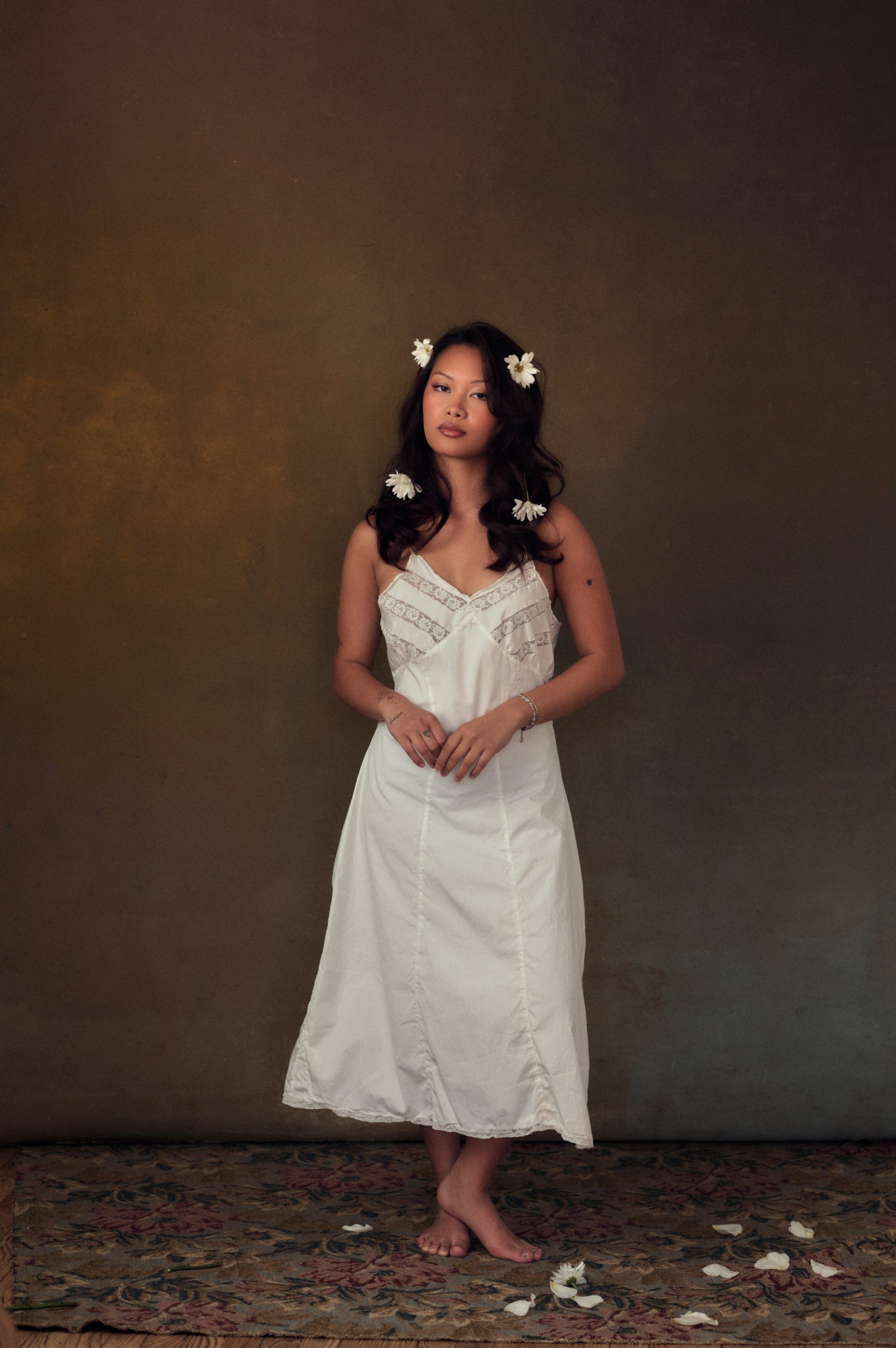 Editorial portrait standing in a white slip dress, florals in the hair