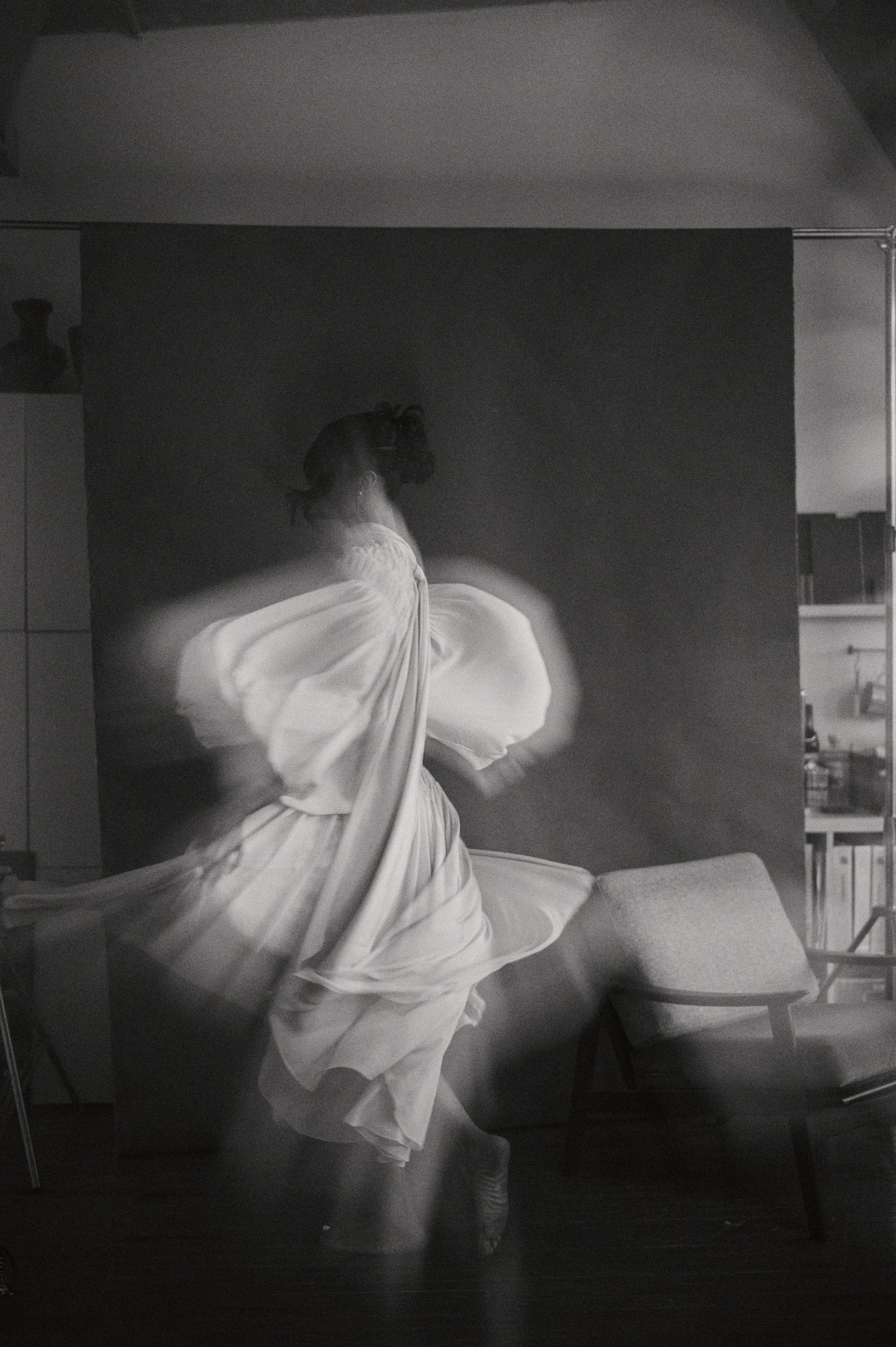 White dress caught mid-motion, painterly blur